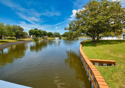 Fountain canal and lake bordered by lawn and trees at Seminole Gardens