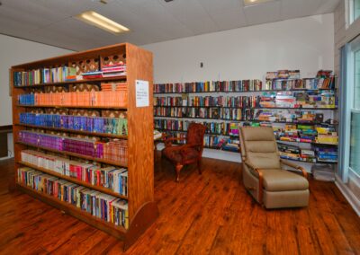 Community library with bookshelves and a reading chair at Seminole Gardens