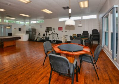Clubhouse game and recreation room with pool table, card table, and fitness equipment at Seminole Gardens